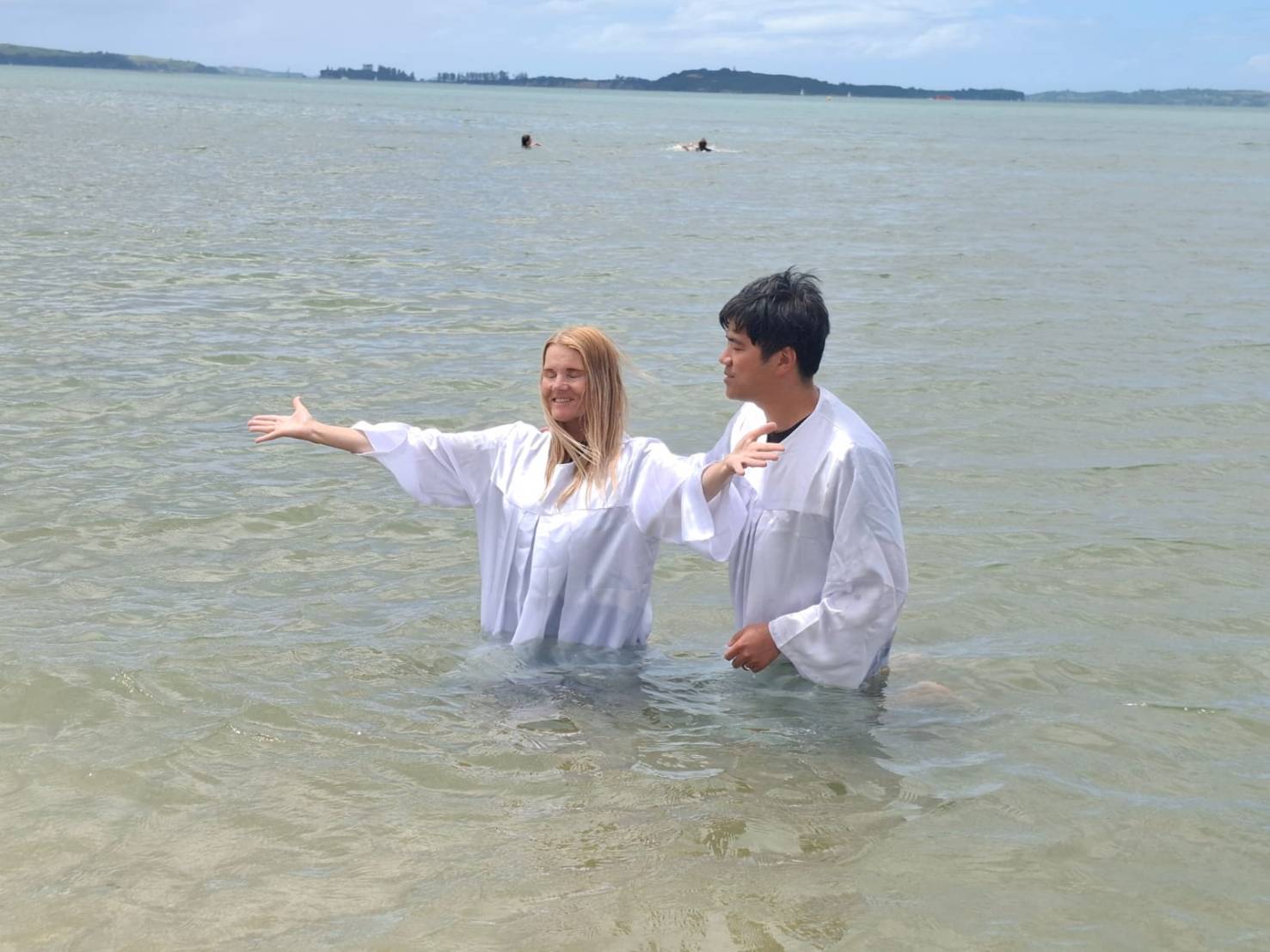 海邊洗禮時，兩位參與者站在海水中